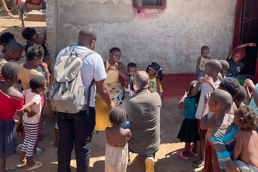 Children gather as a photographer takes pictures of Joshua and Josephine