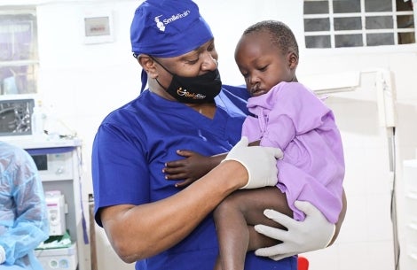 Smile Train medical partner hold boy before surgery