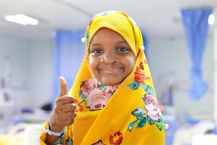 girl give thumbs up in bright yellow clothes