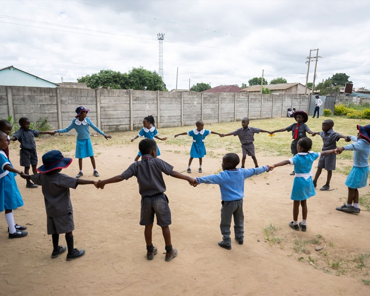 David holding hands in a circle of his friends after cleft surgery