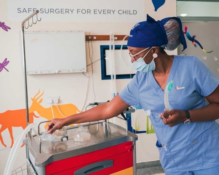 Dr. Elizabeth Igaga working in a solar-powered partner center in scrubs